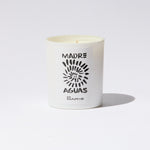 White candle with 'Madre de Aguas' branding on a light gray background