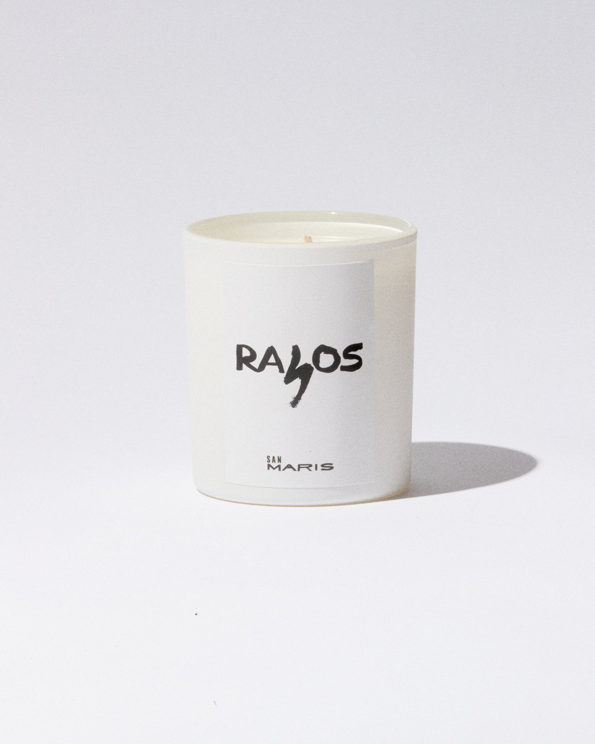 White candle with 'RAIOS' branding on a white background