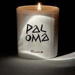 Candle with 'Paloma' and 'San Maris' branding on a dark background