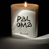 Candle with 'Paloma' and 'San Maris' branding on a dark background