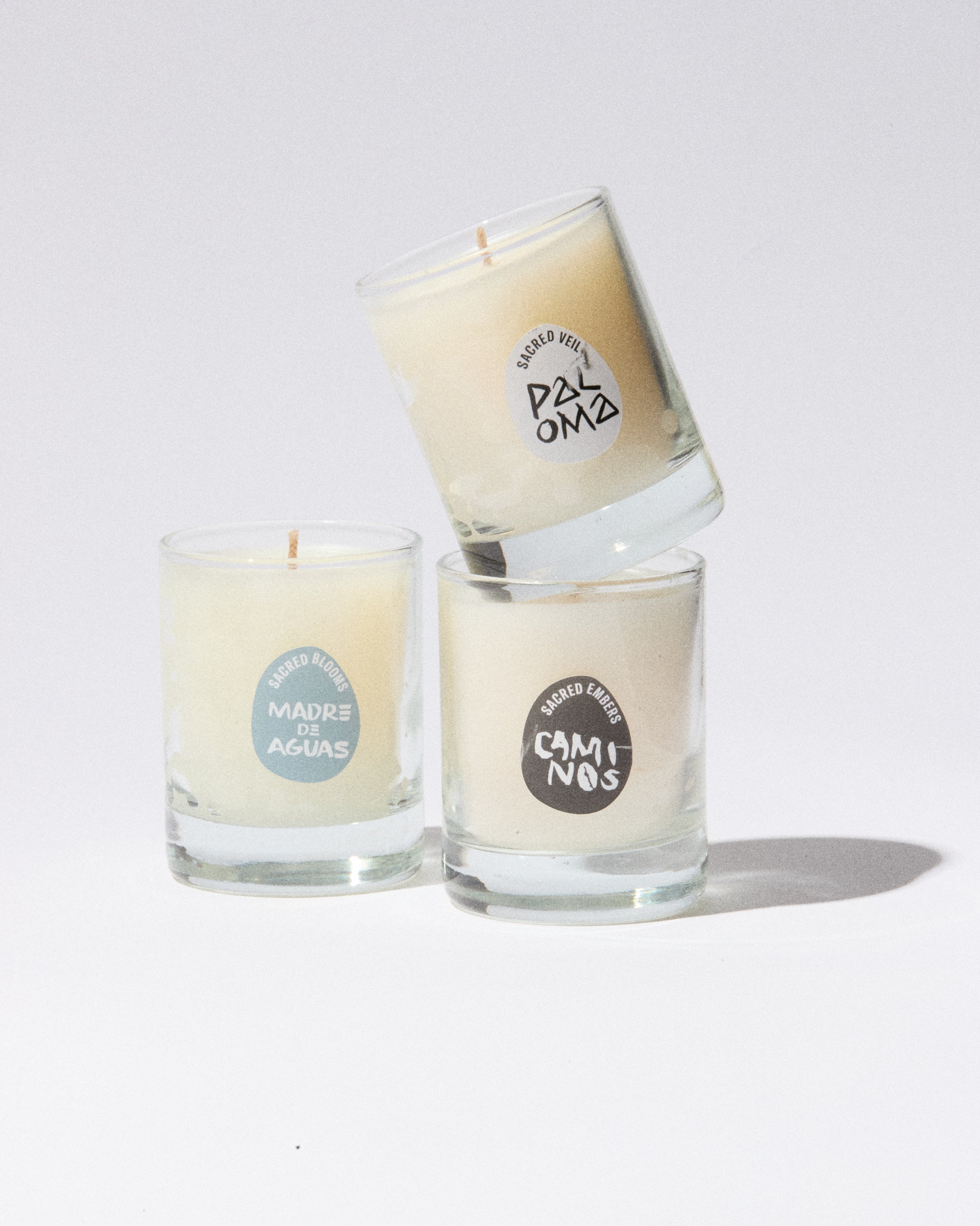 Three glass candles with labels on a white background