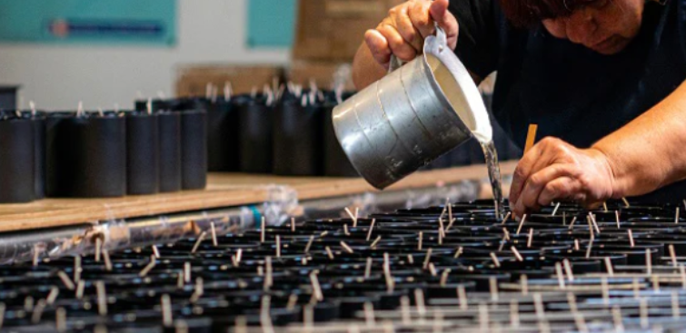Person pouring candles in a workshop setting