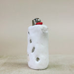 White ceramic lighter holder with textured surface on a beige background