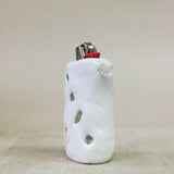 White ceramic lighter holder with textured surface on a beige background