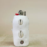 Lighter with cowrie shell designs on a beige background