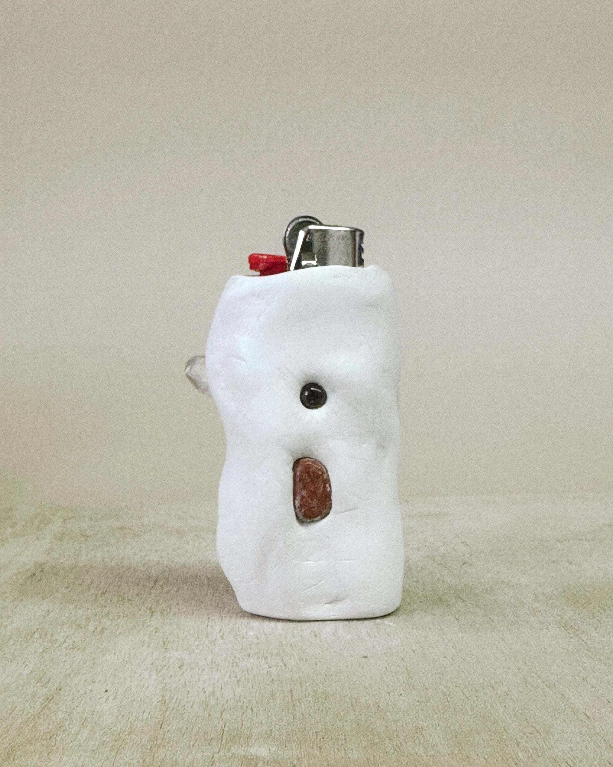 White shaped lighter on a beige surface