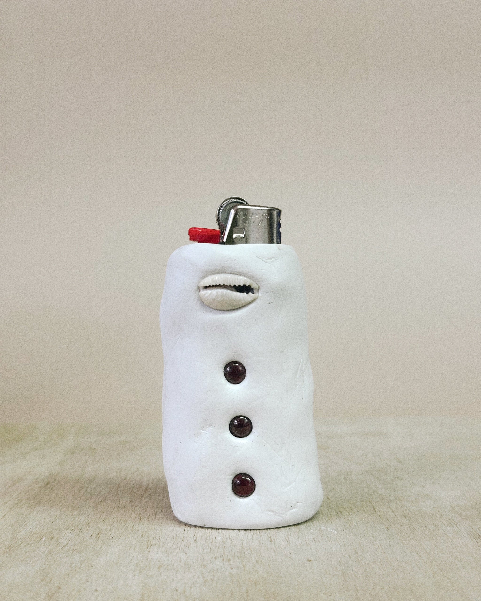 Lighter shaped cover with garnet on a beige background