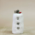 White lighter with textured surface on a beige background