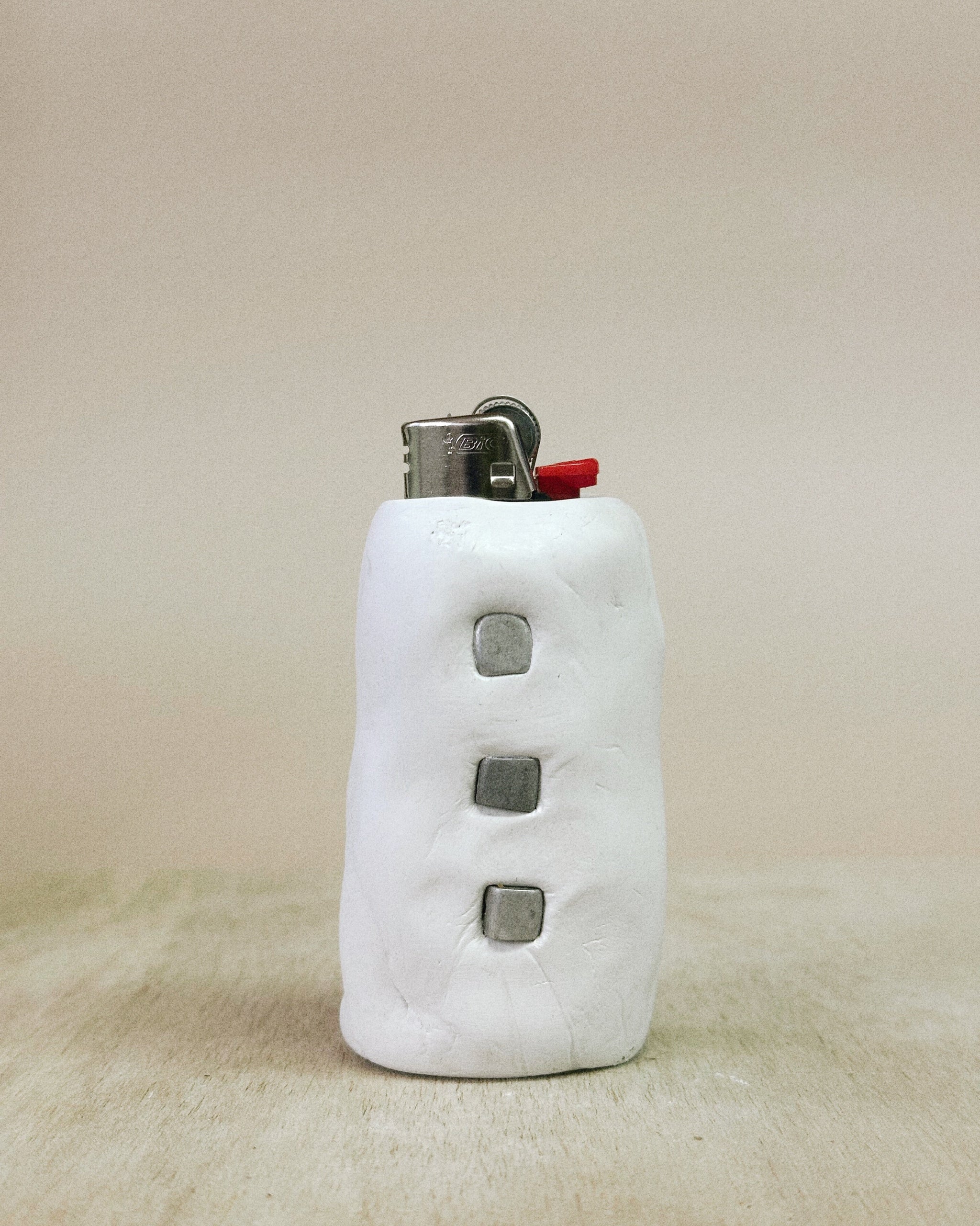 White lighter with textured surface on a beige background
