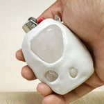 Hand holding a white lighter with a beige background