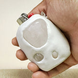 Hand holding a white lighter with a beige background