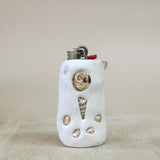 Lighter with shell decorations on a beige background