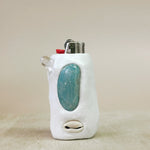 Lighter with a turquoise stone in a white holder on a beige background