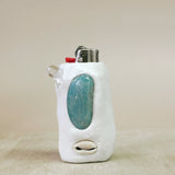 Lighter with a turquoise stone in a white holder on a beige background