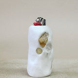 Lighter with decorative stones on a beige surface