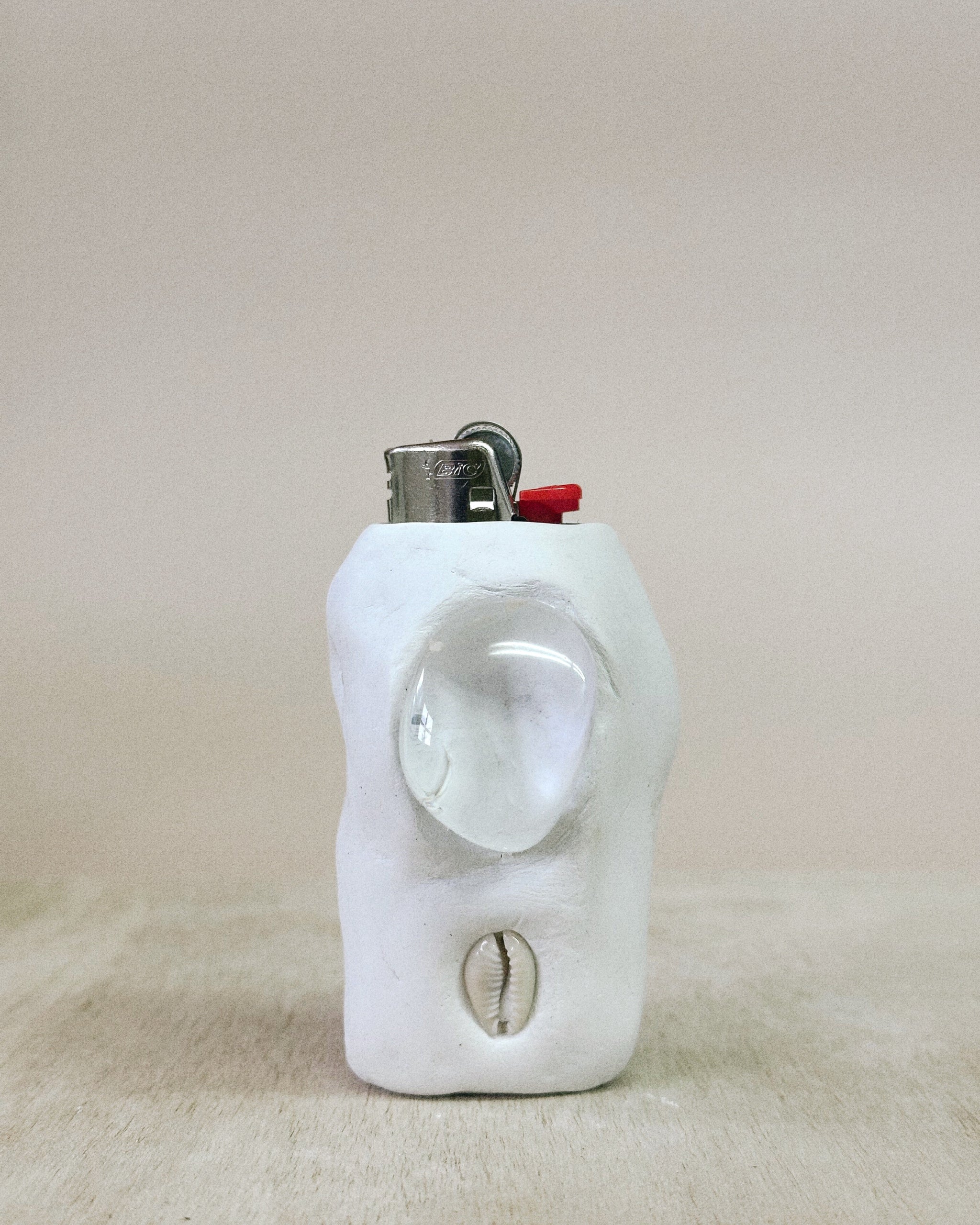 White ceramic object lighter on a beige surface