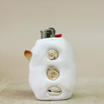 White ceramic lighter with shell designs on a beige background