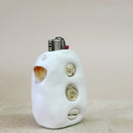 White ceramic lighter with shell designs on a beige background
