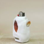 White ceramic lighter case with decorative elements on a beige background