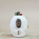 White lighter with a shell design on a beige background
