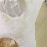 Crystal and brown stone on a white surface