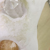 Crystal and brown stone on a white surface