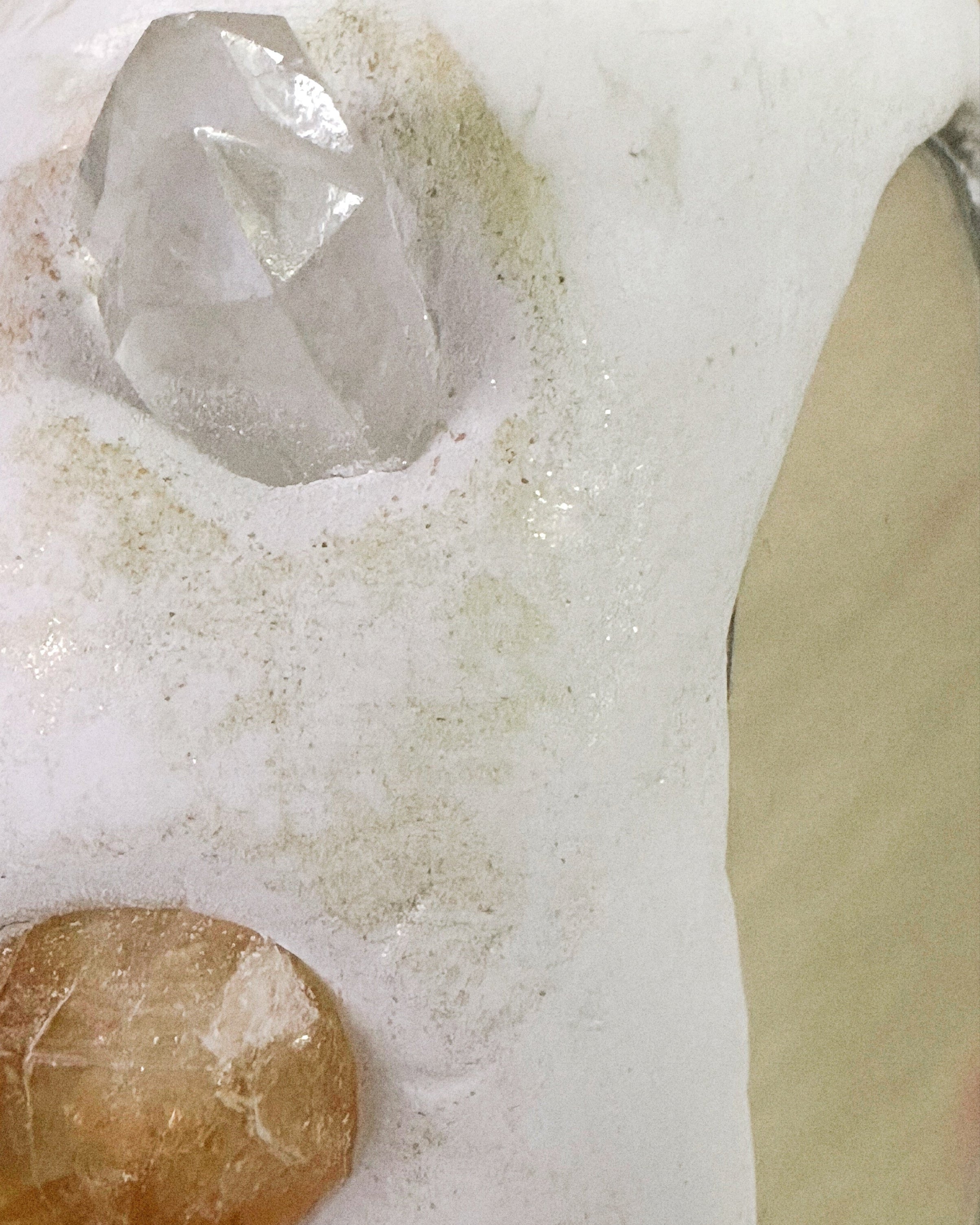 Crystal and brown stone on a white surface