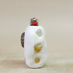 White stone lighter with citrineinclusions on a beige background