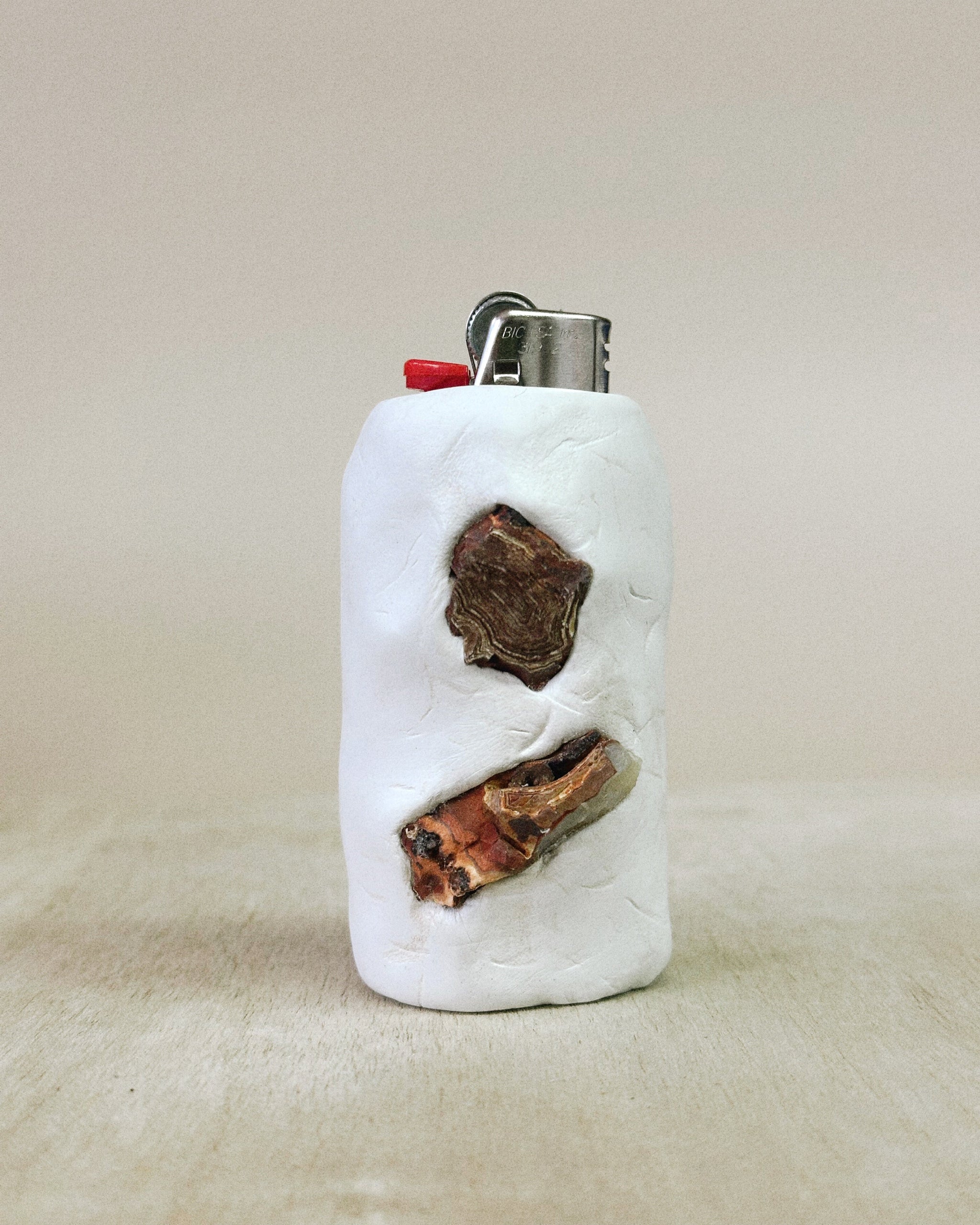 White lighter with carnelian accents on a beige background