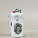 White ceramic lighter with face design on a beige surface