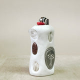 White ceramic lighter with decorative elements on a beige background