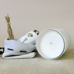 White ceramic container with a lid, featuring decorative elements on a beige surface.