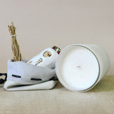 White ceramic container with a lid, featuring decorative elements on a beige surface.