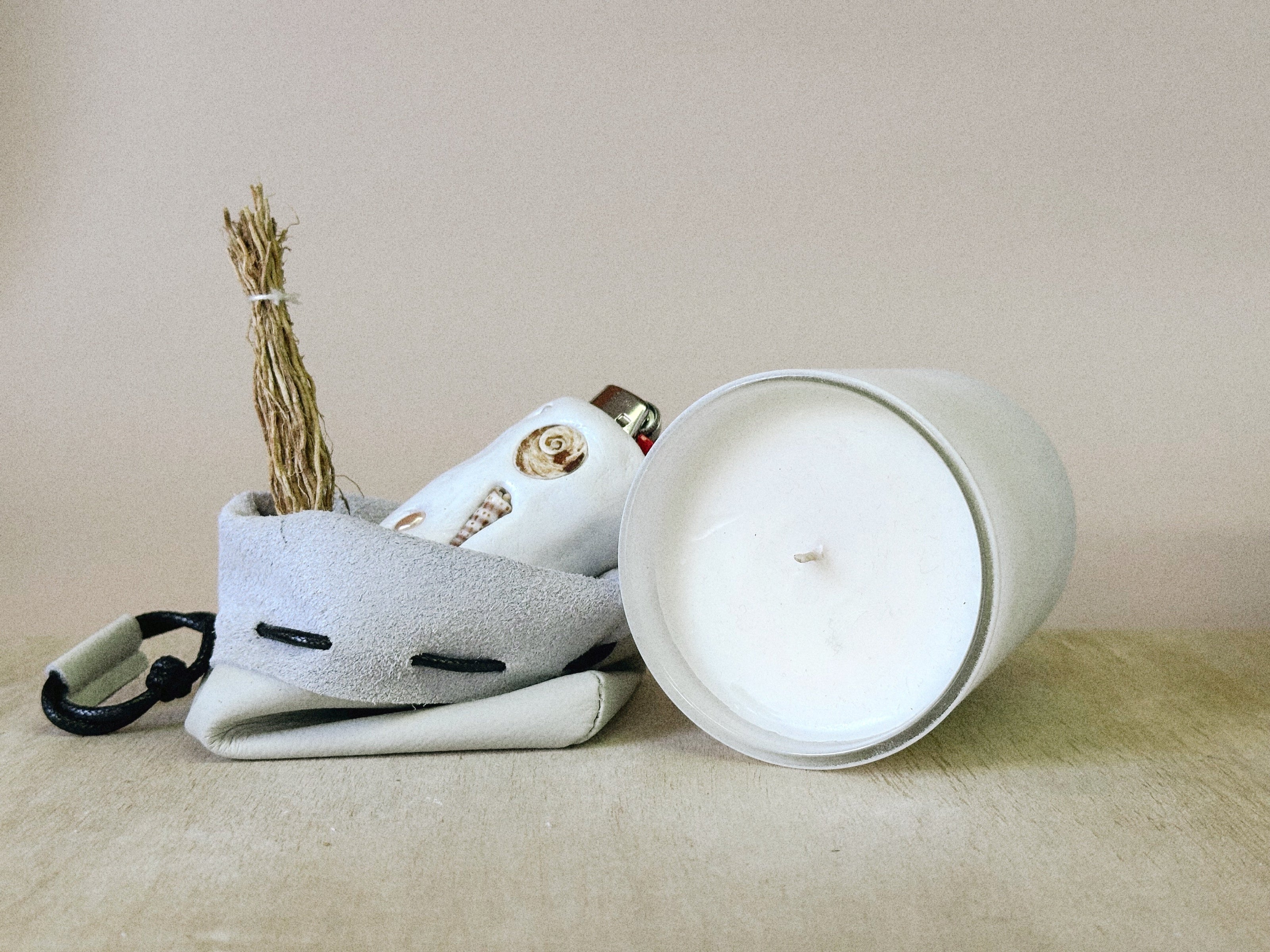 White ceramic container with a lid, featuring decorative elements on a beige surface.