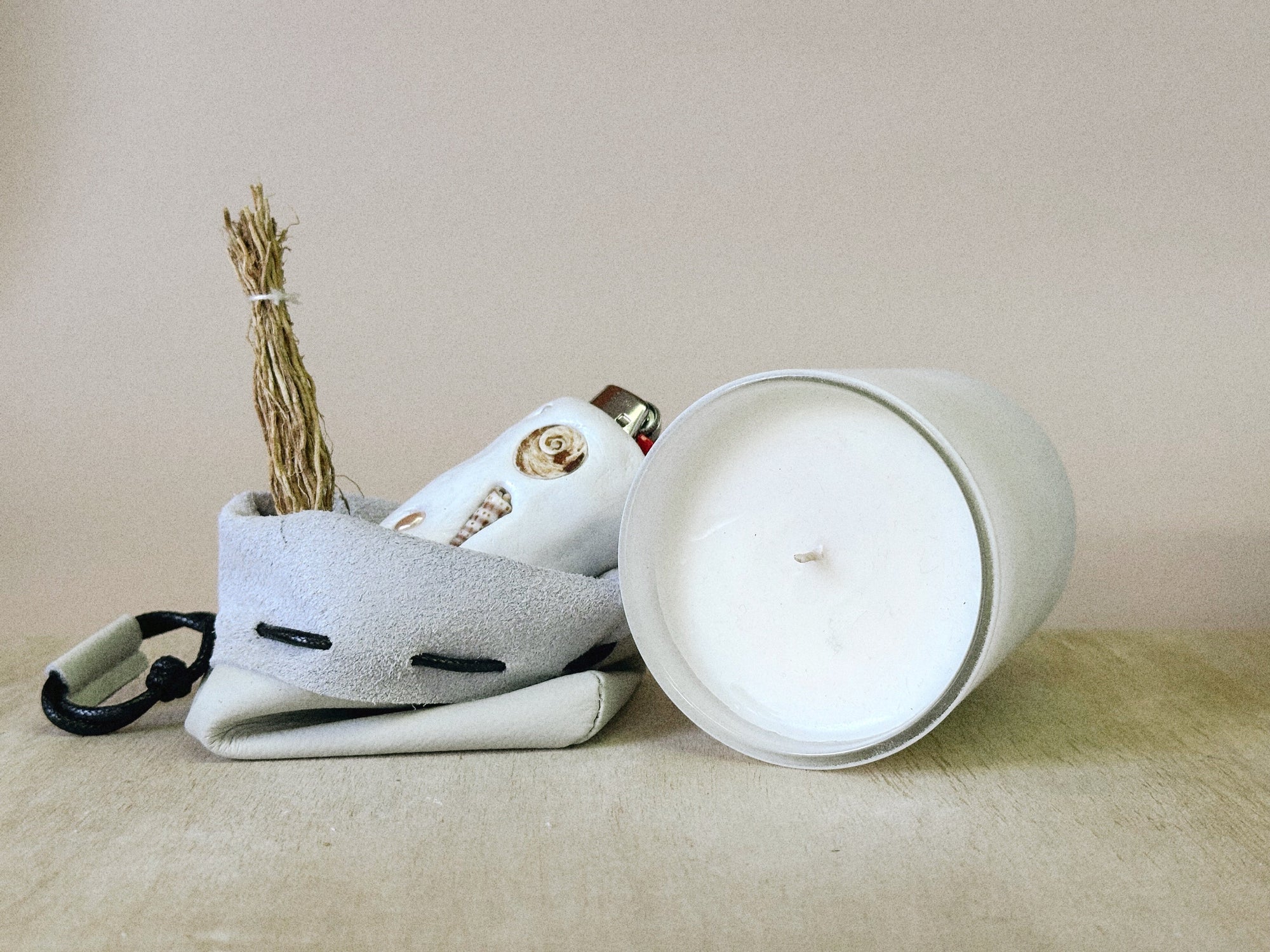 White ceramic container with a lid, featuring decorative elements on a beige surface.