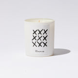 Oyá ritual candle by San Maris in a white glass vessel with hand-drawn X marks